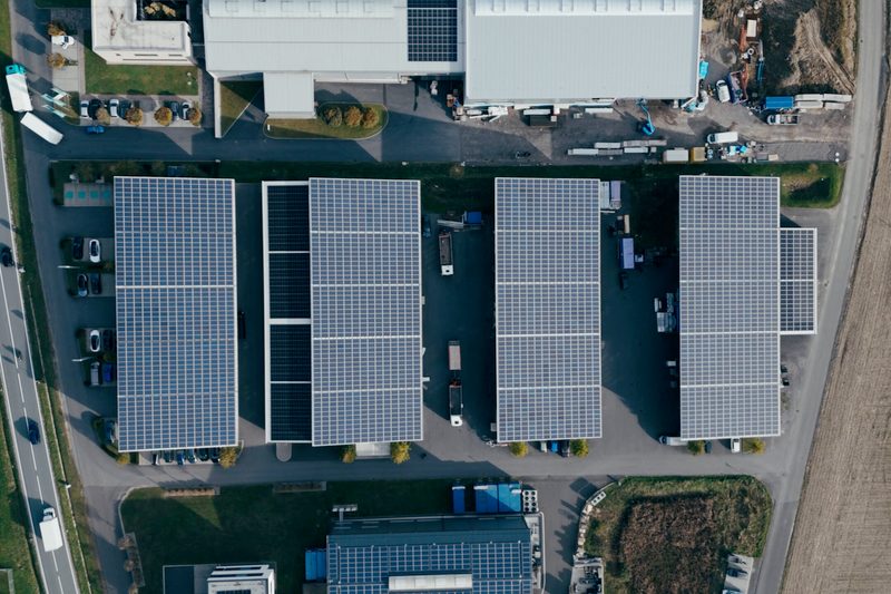 Luftaufnahme von vier Firmenhallen mit Photovoltaik in Berndorf, Steiermark